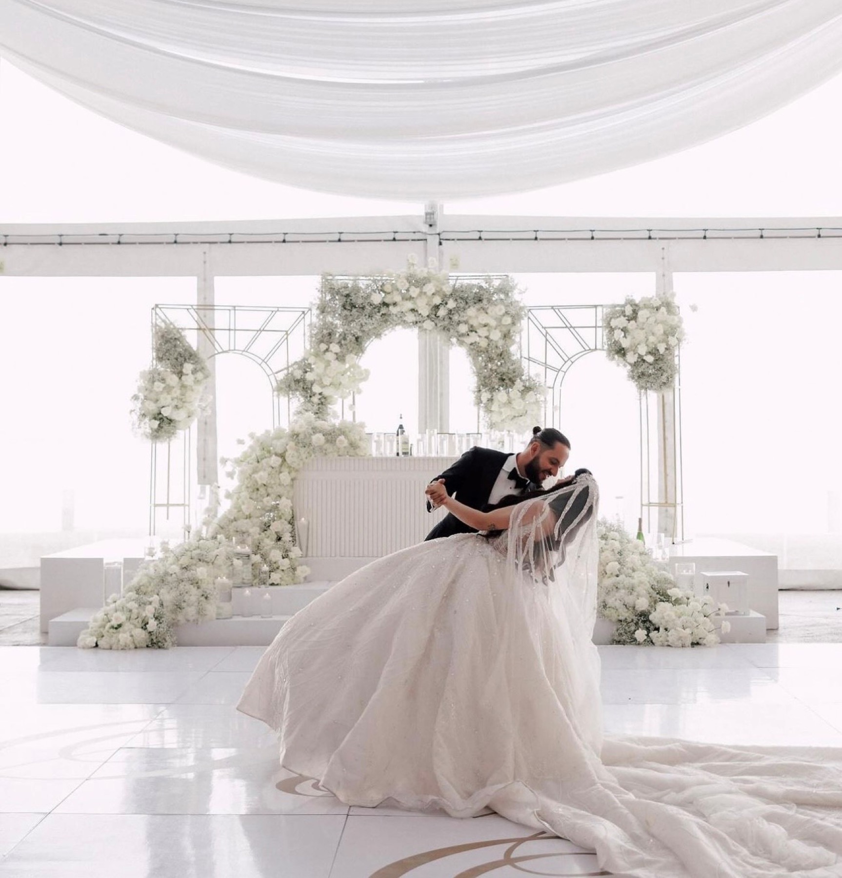Newlyweds on the dance floor beneath the drapes
