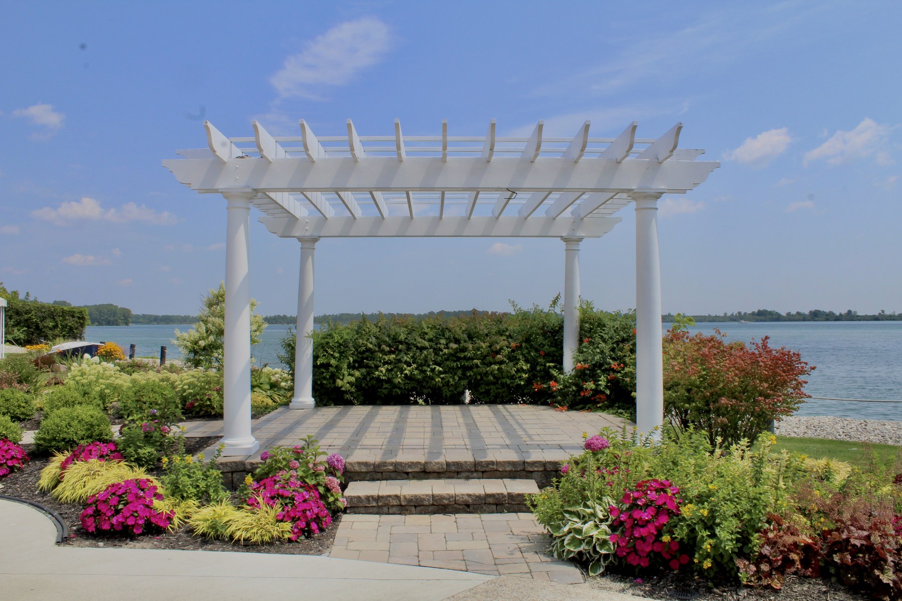 The waterfront pergola with flower beds and the open river behind it