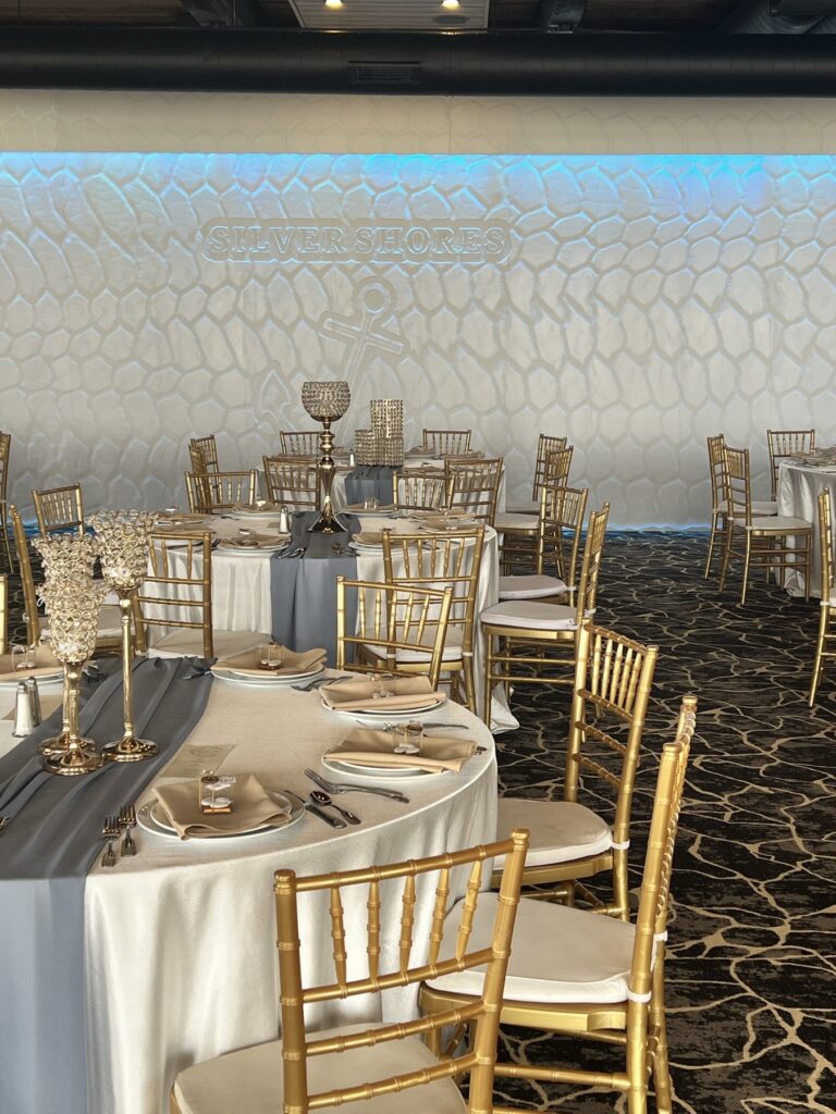 Gold chiavari chairs and gold candelabra centerpieces set in the ballroom