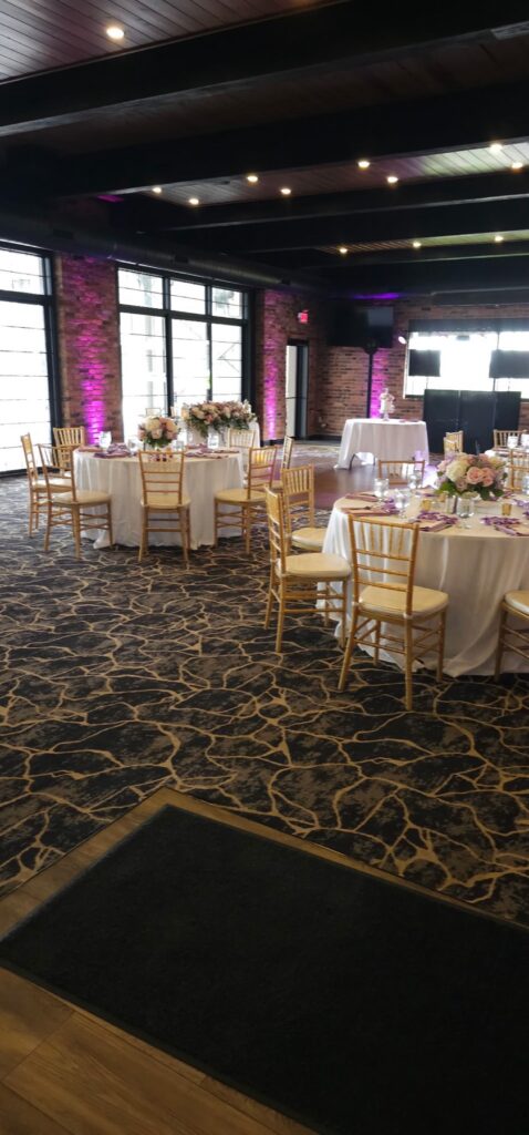 A reception room with exposed brick walls and pink uplighting